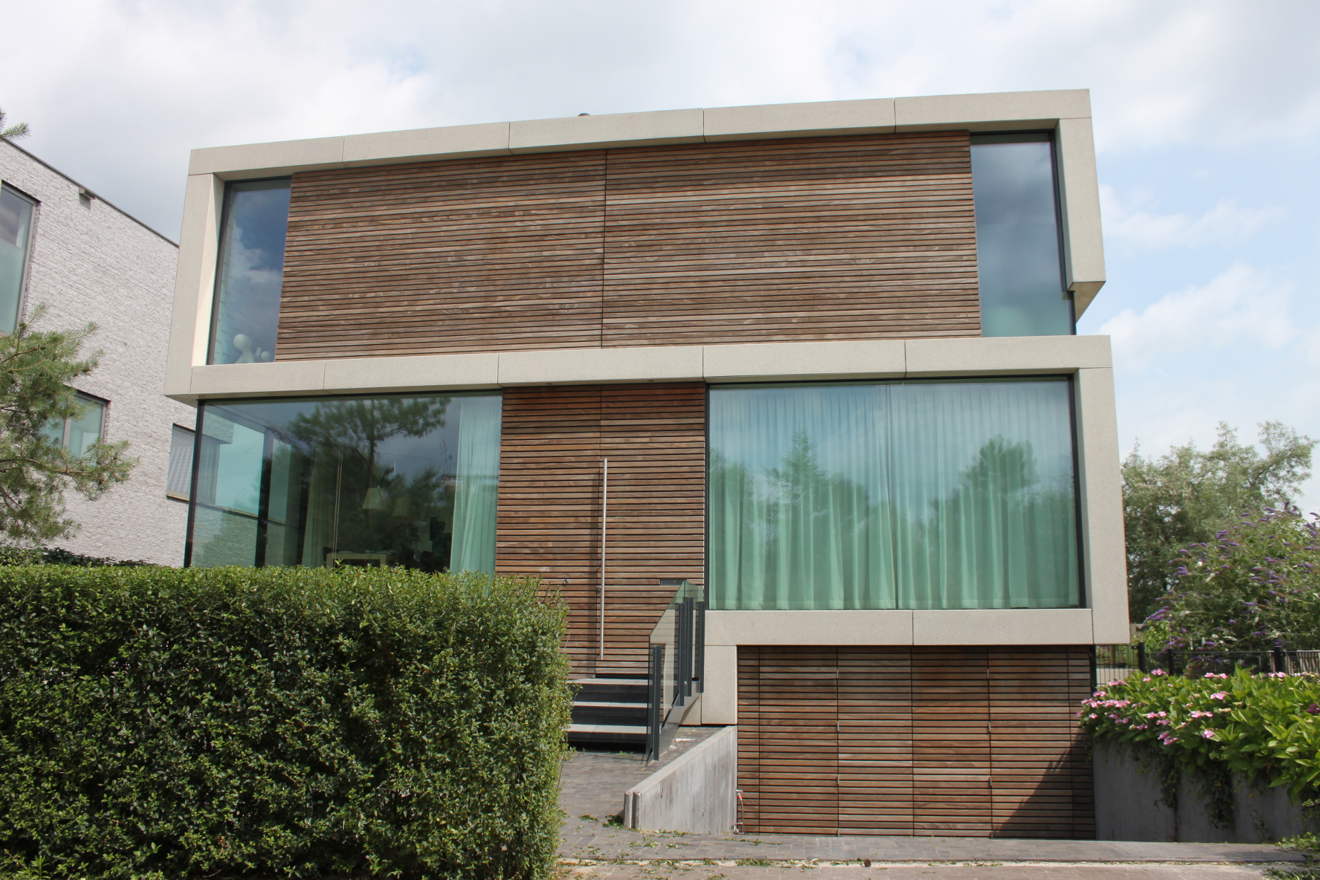 voorkant woning met grote ramen en houten gevel