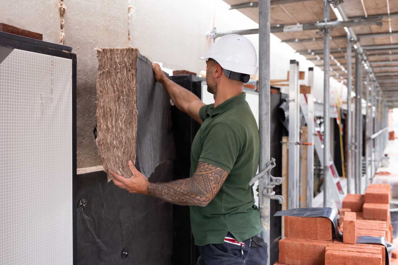 Bouwvakker plaatst isolatiemateriaal