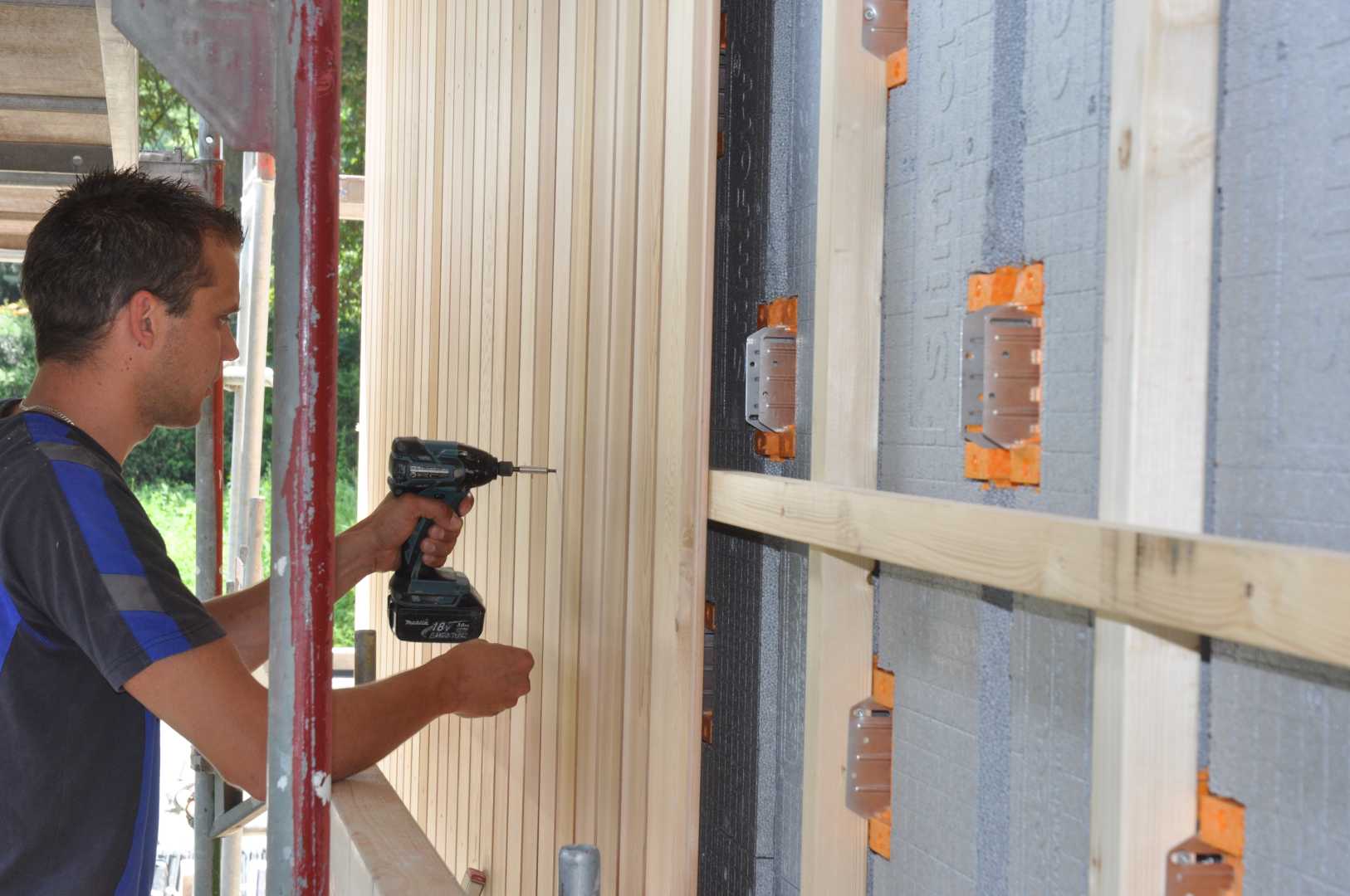SlimFort houten gevelbekleding Bouwvakker bekleed een gevel met hout