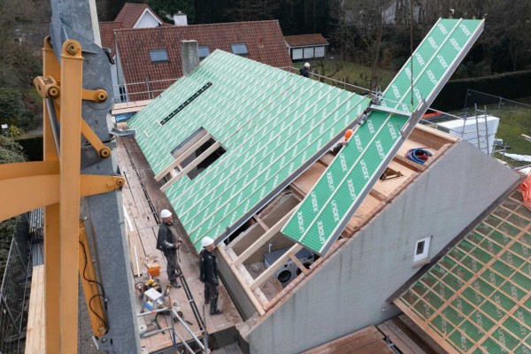 Hijskraan tilt isolatiepaneel op een dak