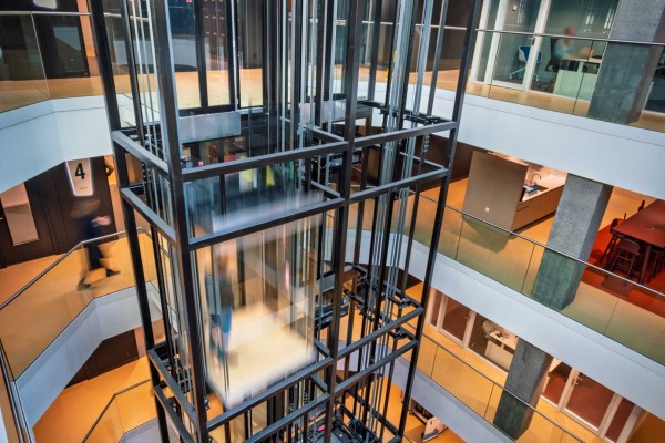 Stalen liftschacht met lift in beweging