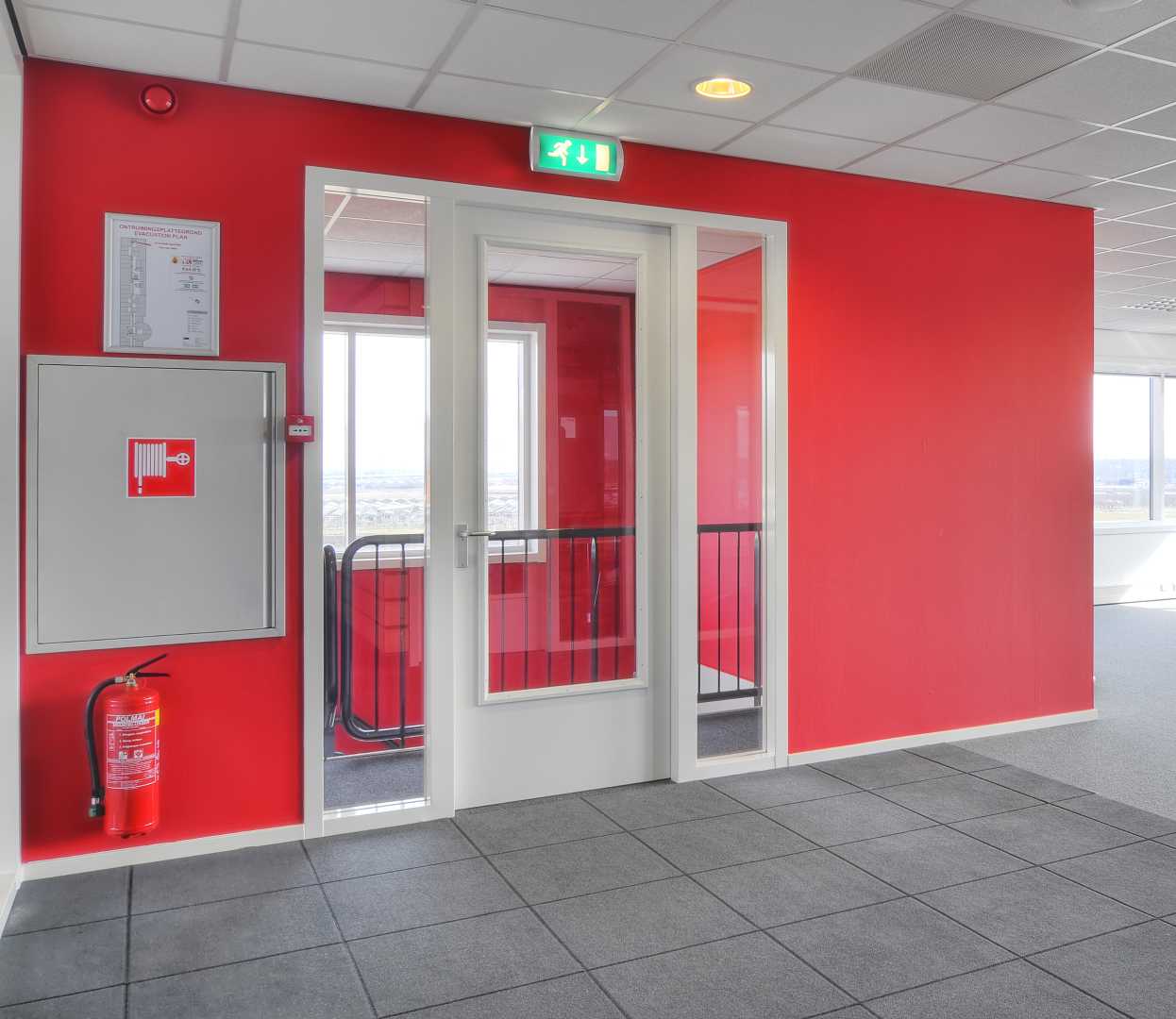 Brandwerend stalen kozijn Rode muur met brandwerend stalen kozijn