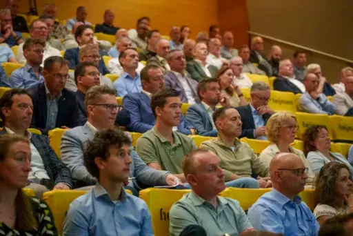 De zaal zat vol met geinteresseerde vertegenwoordigers van de Prefab-branche zaal vol met geïnteresseerde luisteraars