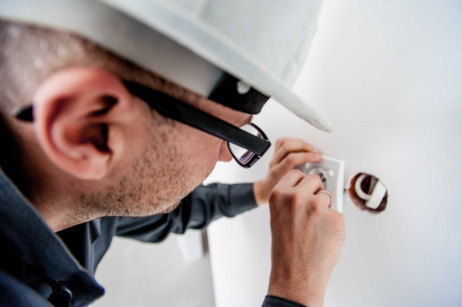 Wat houdt een NEN3140 cursus in? elektricien plaatst stopcontact