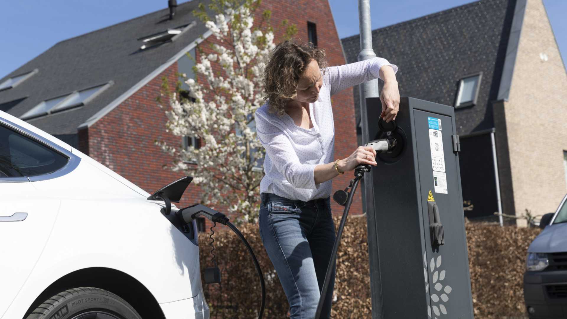 Grote potentie om elektriciteitsnet te ontlasten met thuis bidirectioneel laden vrouw doet stekker in laadpaal