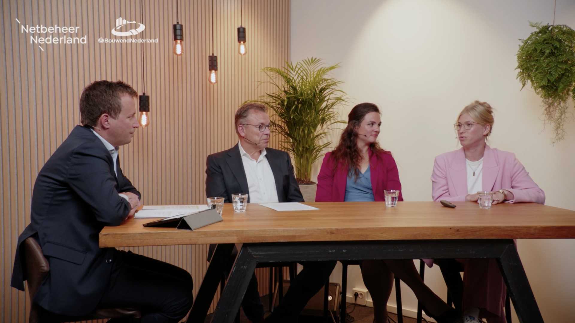 Netbeheerders en bouwers in gesprek over netbewust bouwen twee mannen en twee vrouwen overleggen aan tafel