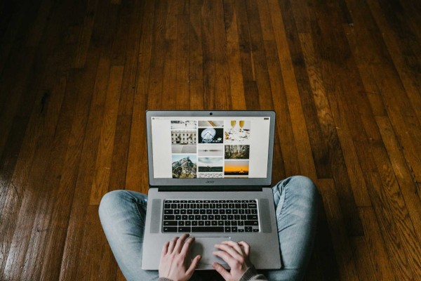 Man met laptop zittend op een vloer