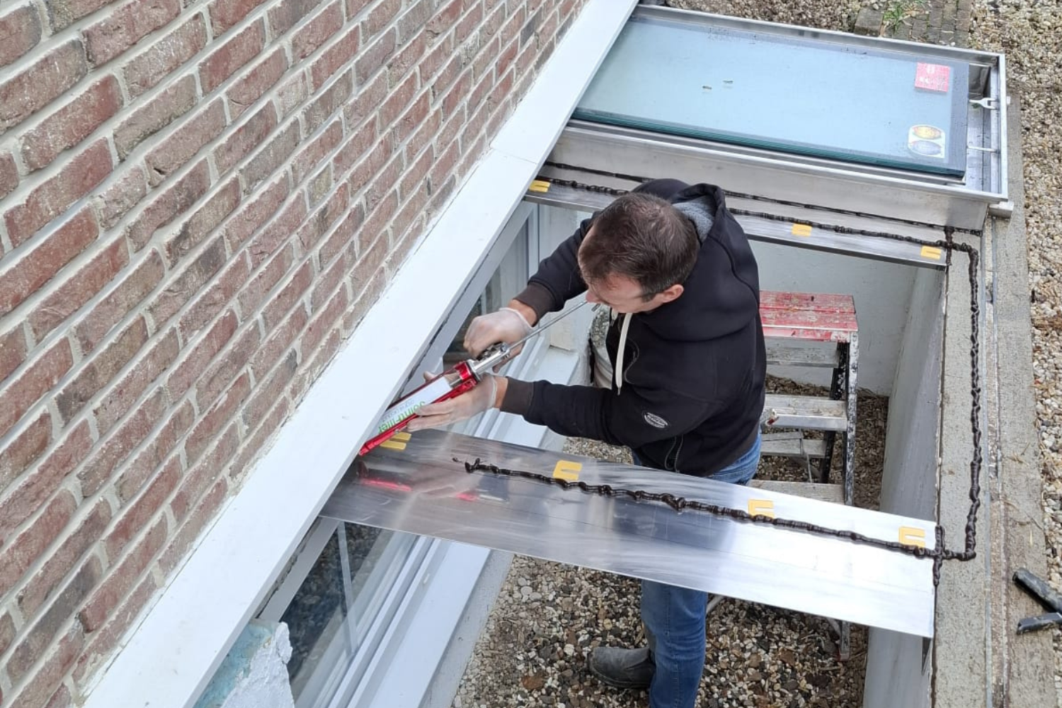 Monteur plaatst een kitrand voor een koekoek Monteur plaatst een kitrand voor een koekoek