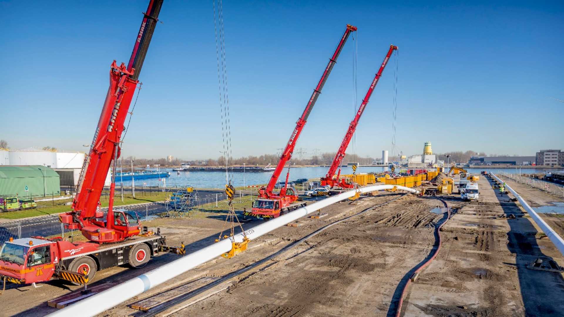 Netwerkbedrijven blij met aannemen nieuwe Warmtewet, belangrijke stap voor het energiesysteem Rode hijskranen tillen buizen op