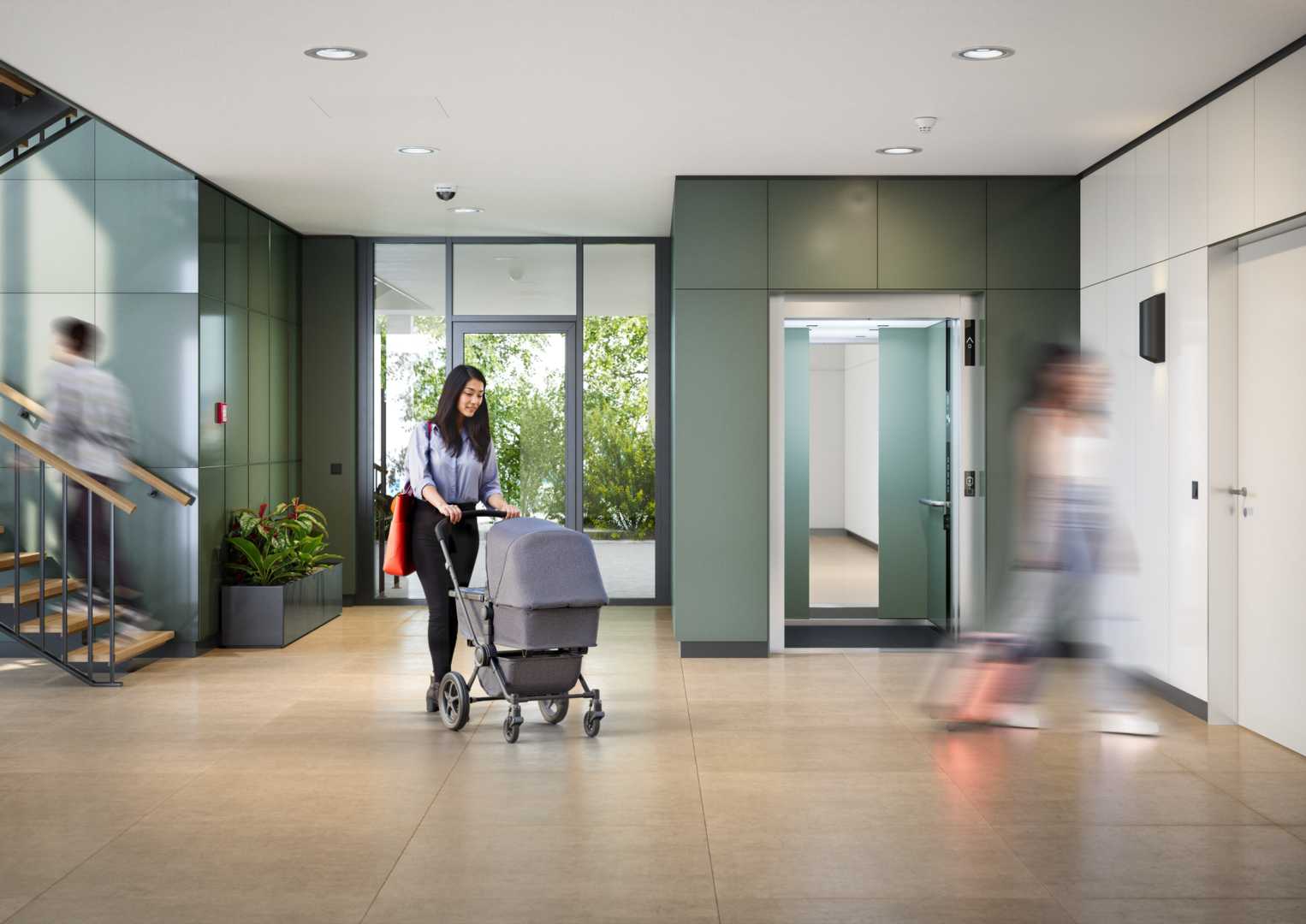 Schindler 3000 EU - Lobby KV Vrouw met kinderwagen in trappenhuis met liften