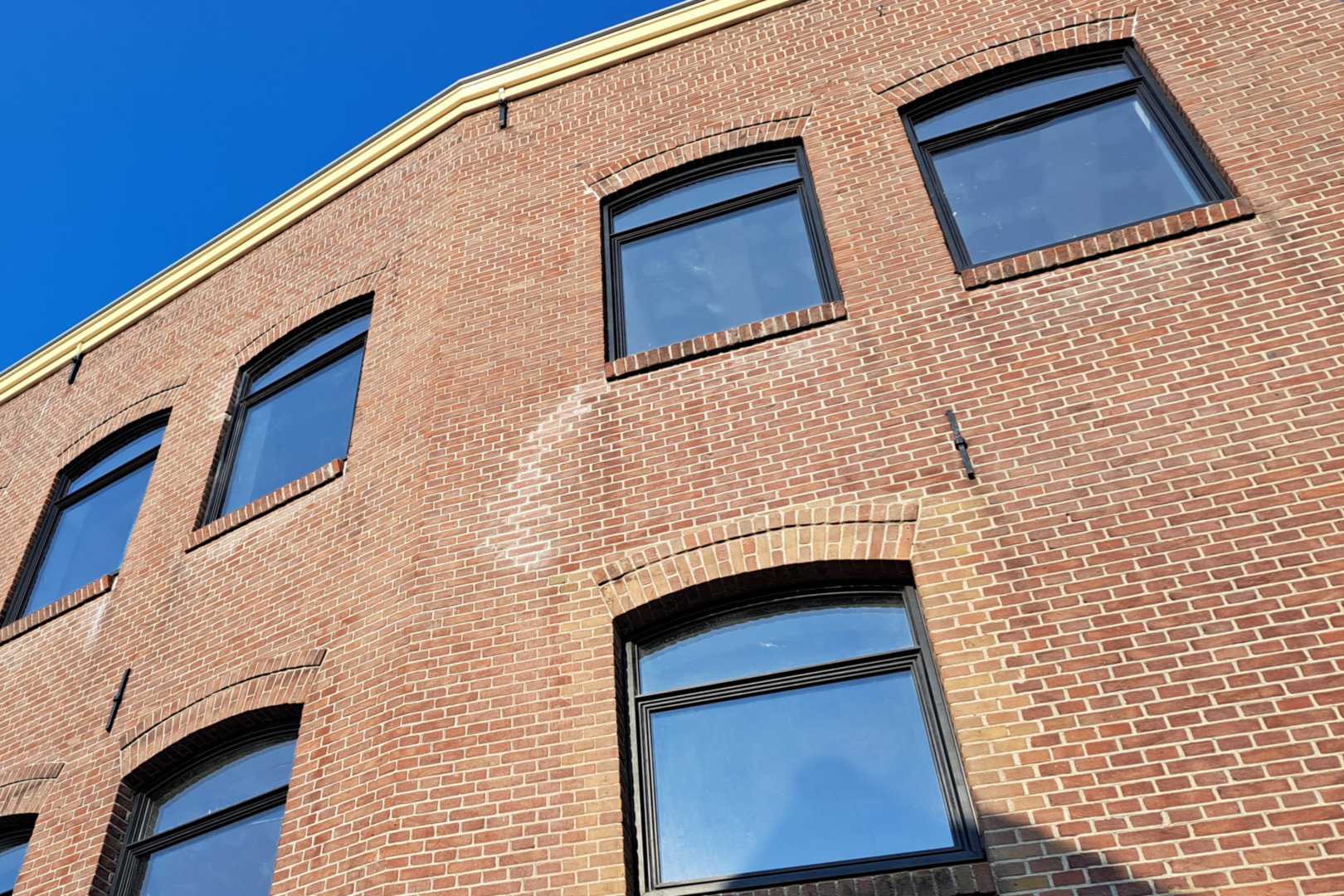 Gevel van een bakstenen gebouw met aluminium kozijnen