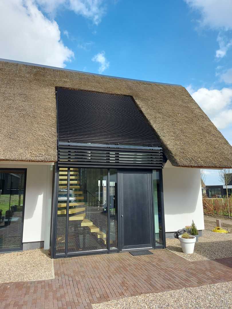 De daklichtlamellen van deze villa integreren naadloos met die van de zonwering boven de entree